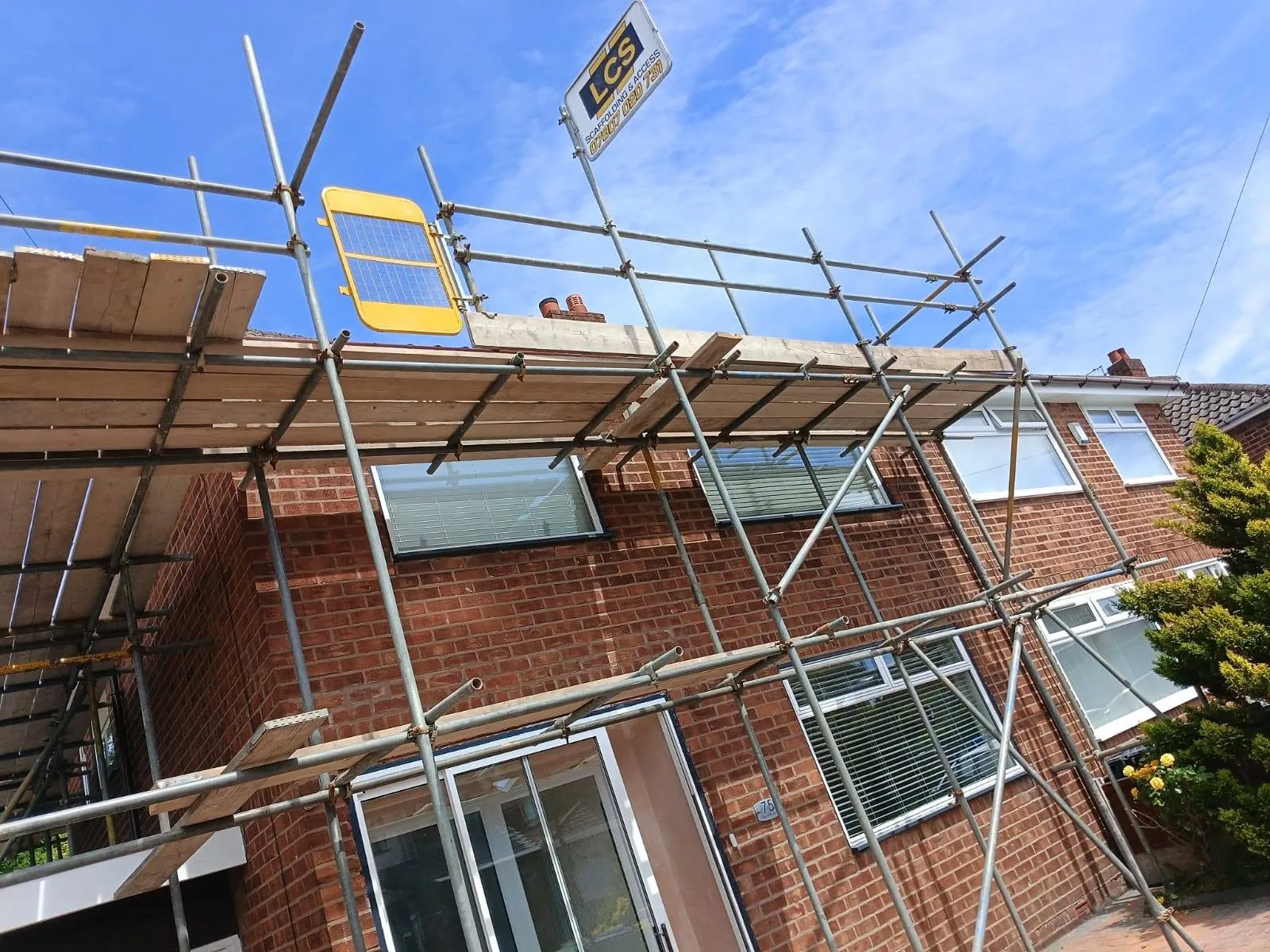 Roofline scaffold on a domestic brick property with LCS signage