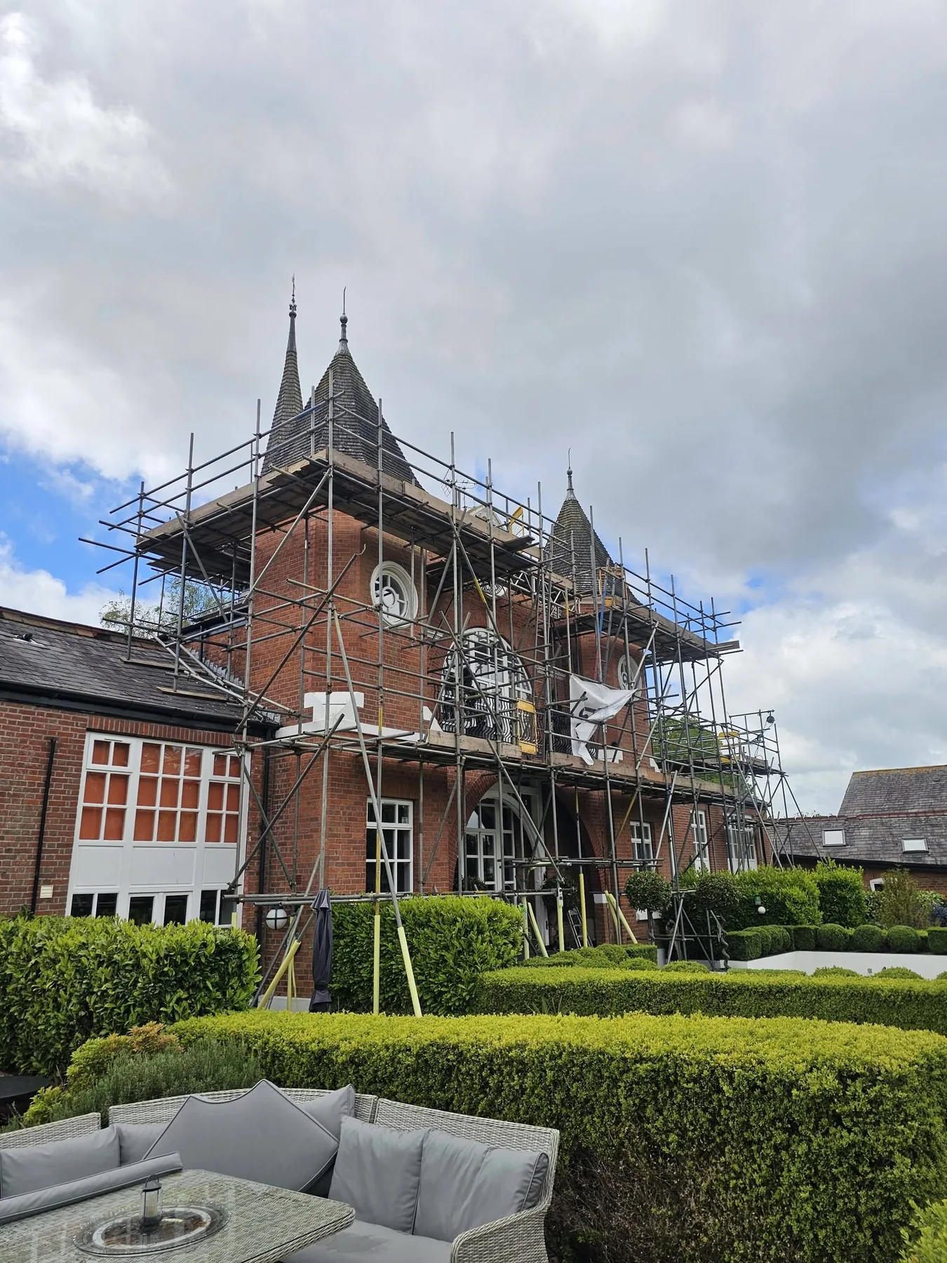 Scaffold erected around a heritage building roof and garden area