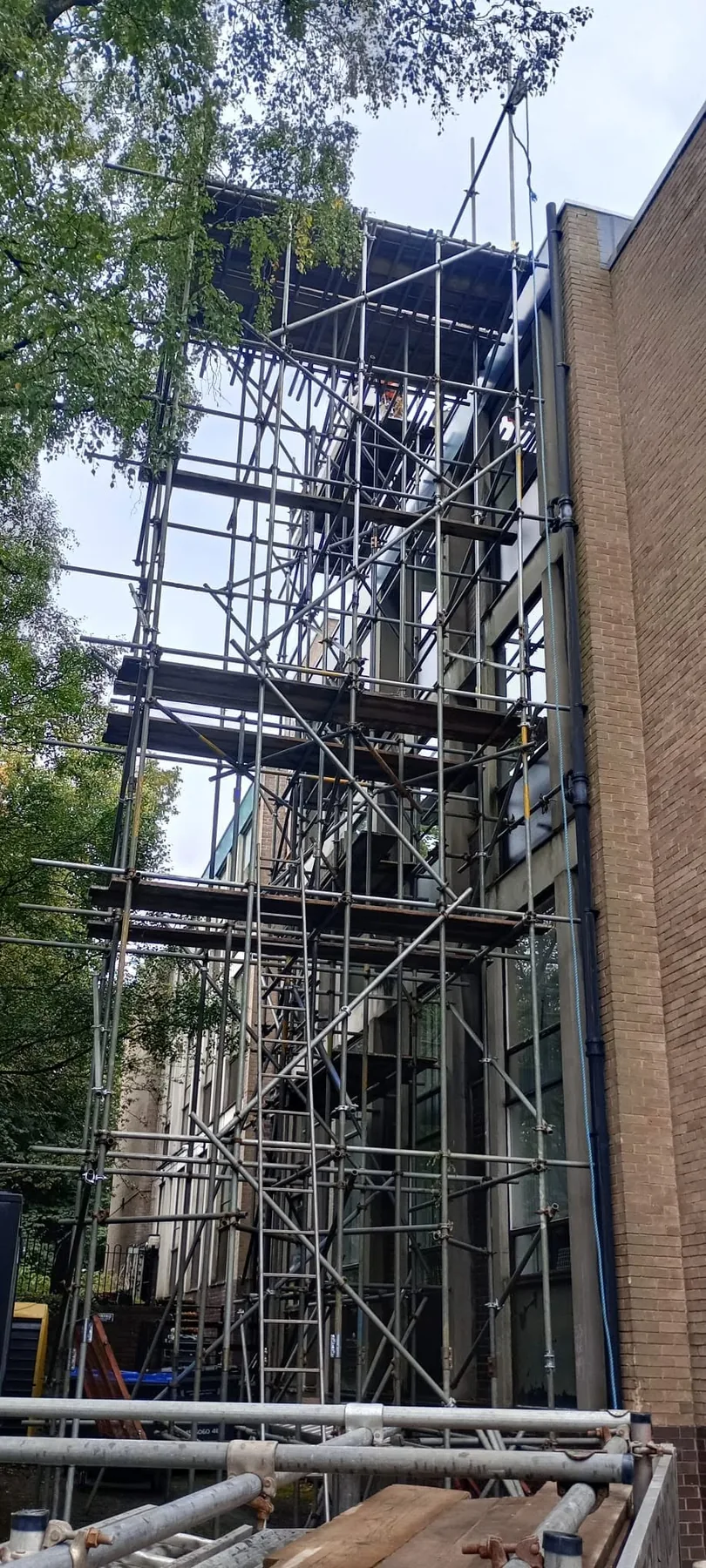 Tall scaffold tower access between urban buildings
